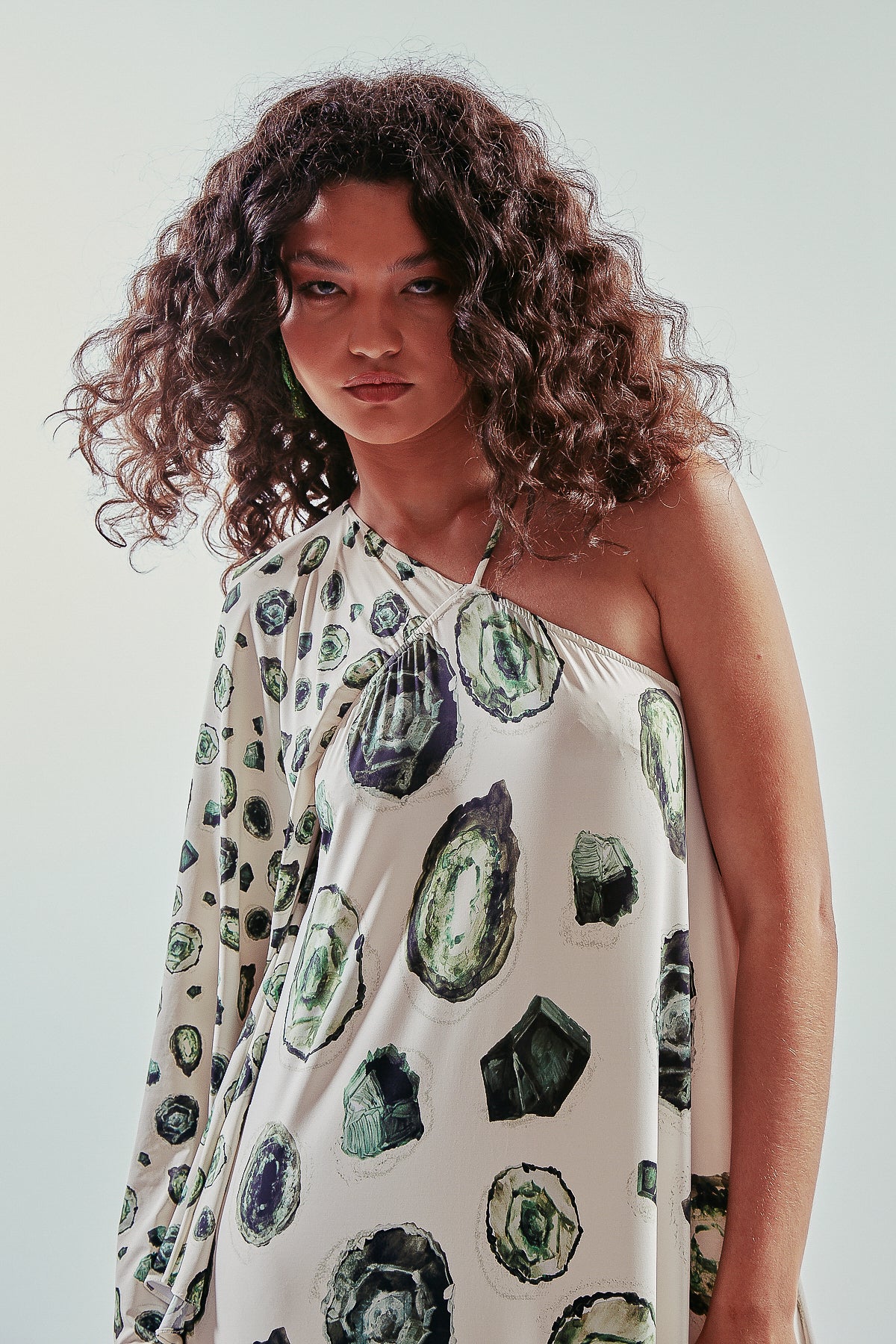 Vestido largo y asimétrico de una manga larga, estampa esmeraldas, con vuelo y volantes