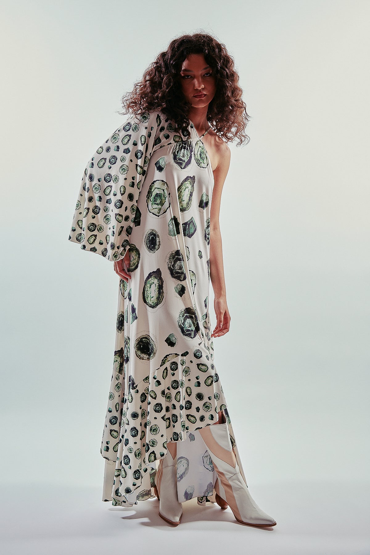 Vestido largo y asimétrico de una manga larga, estampa esmeraldas, con vuelo y volantes